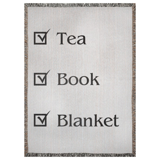 A woven blanket with a checklist that says "tea", "book", "blanket".