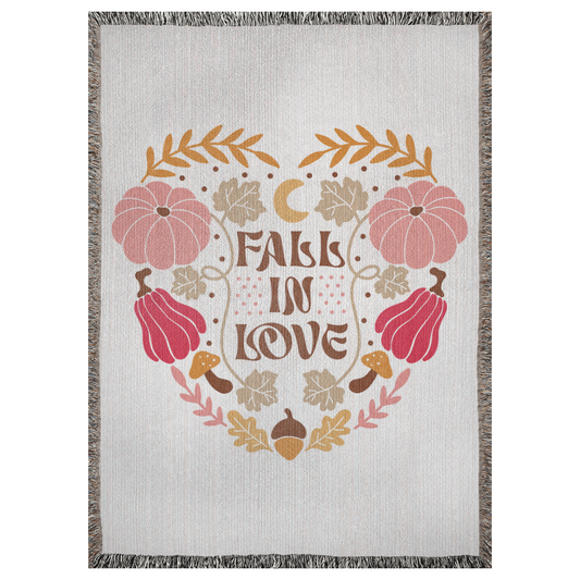 A 37x52 inch woven blanket depicting bohemian-style pumpkins, acorns, leaves, and a moon. It says "fall in love".