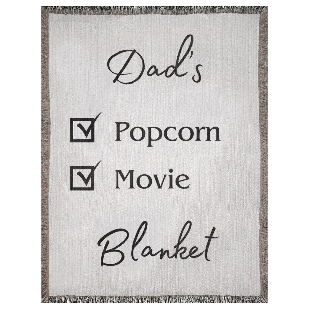 A personalized woven blanket with a name and checklist. This example says "Dad's Popcorn Movie Blanket". 